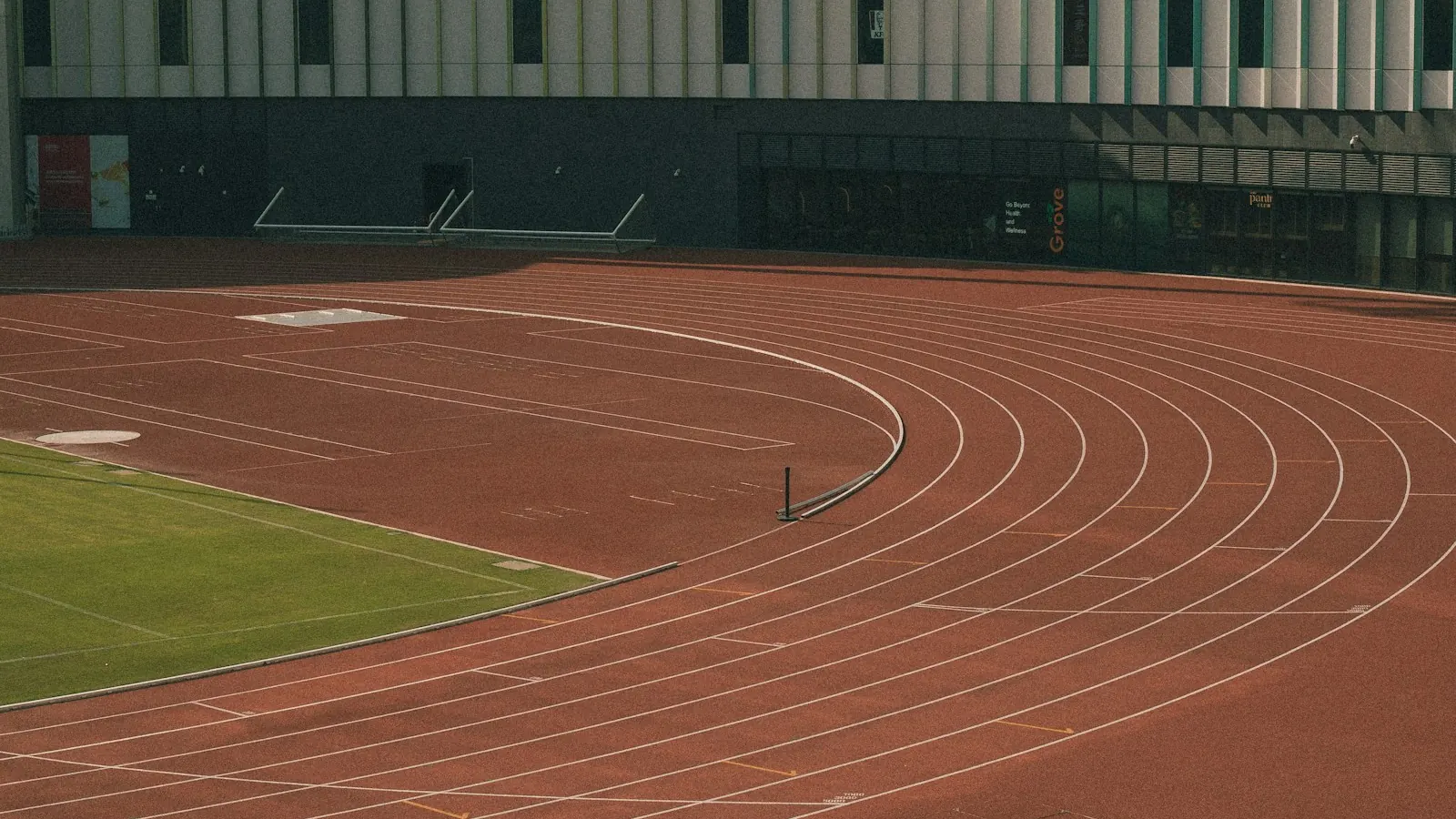 Curva de una pista de atletismo vacía junto al graderío