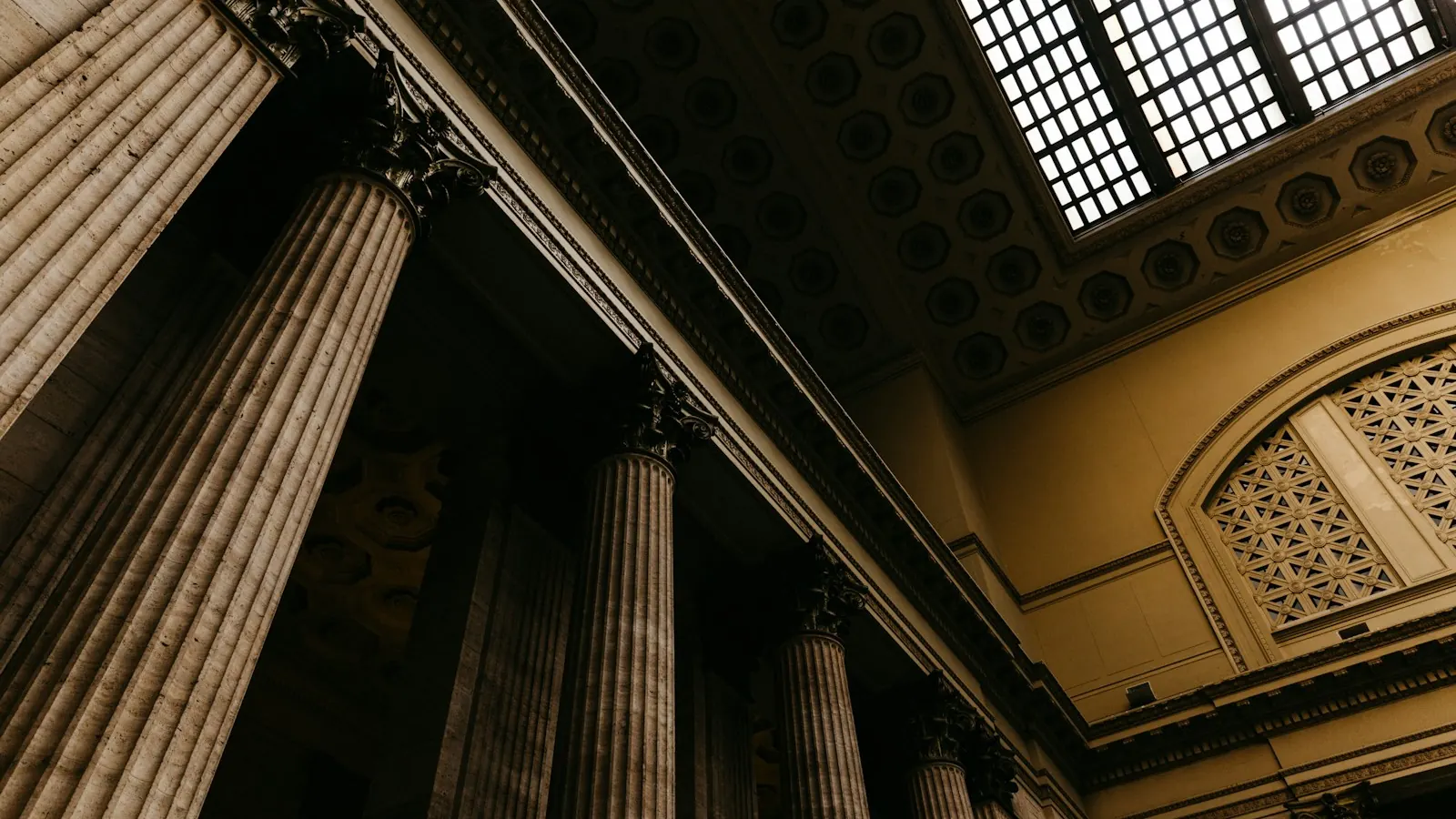 Columnas de piedra y techo artesonado en el interior de un edificio judicial