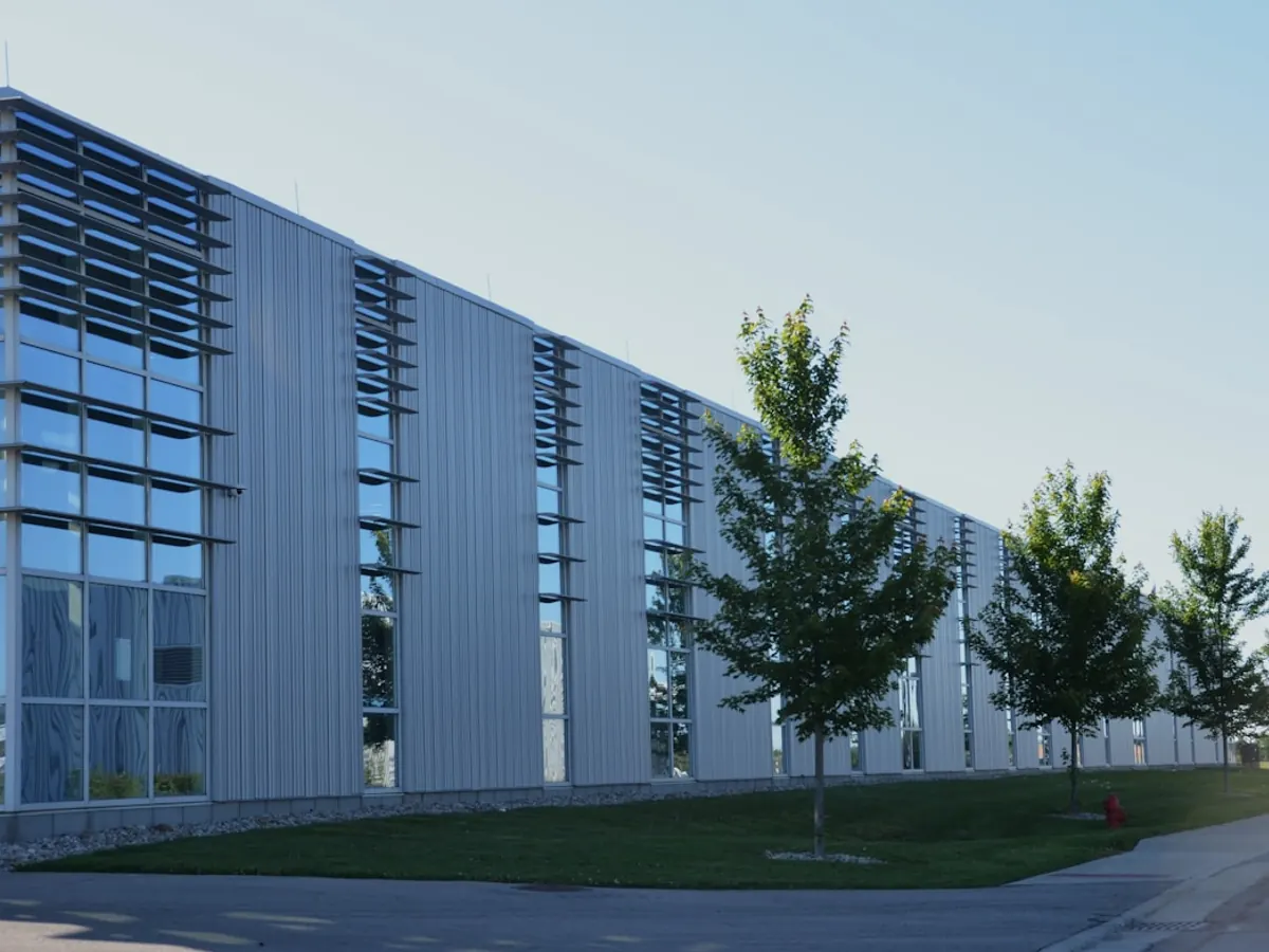 Edificio moderno de oficinas con grandes ventanales y arbolado